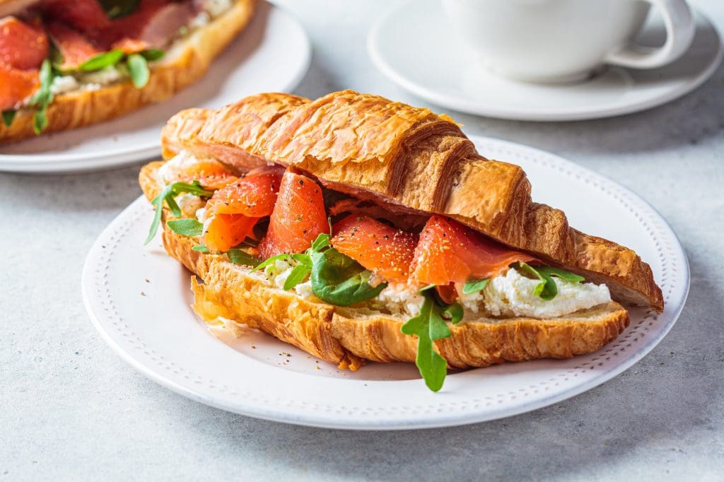 Croissant sandwich with cream cheese, salmon and arugula