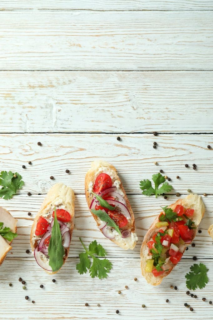Delicious italian snacks bruschetta on white wooden background