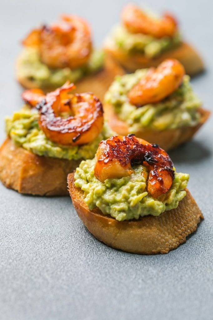 Appetizer canape with shrimp on cutting board on table close up