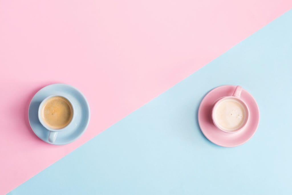 Creative pastel blue pink background with two ceramic cups of freshly brewed coffee drink