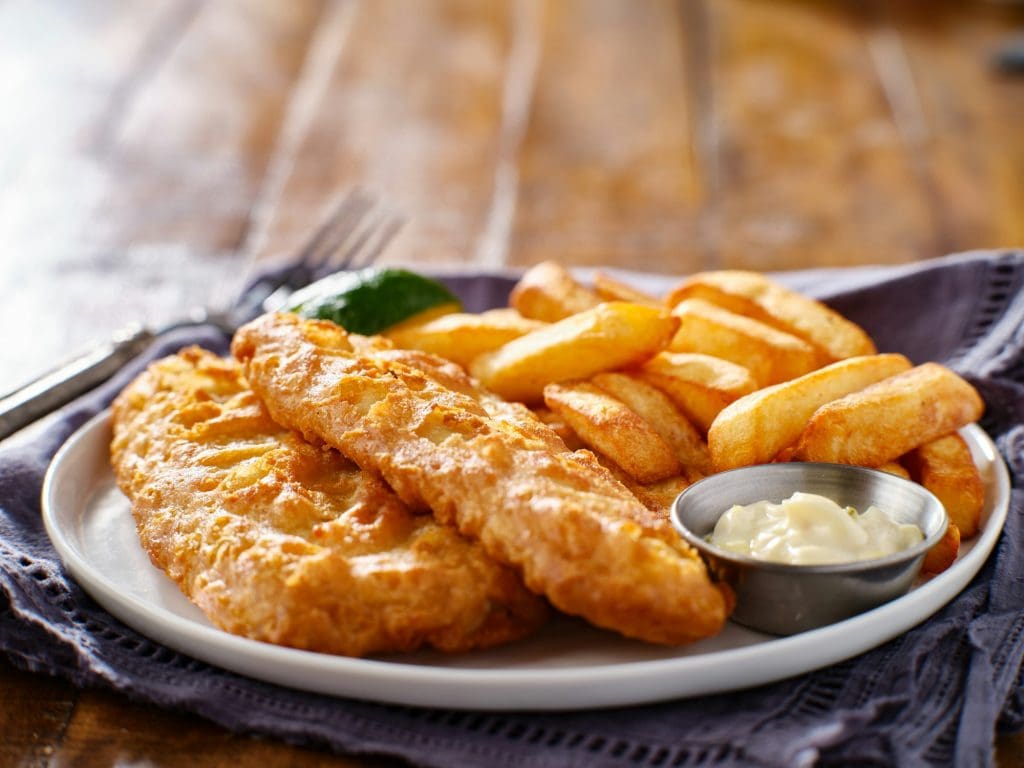 fish and chips on plate with tartar sauce