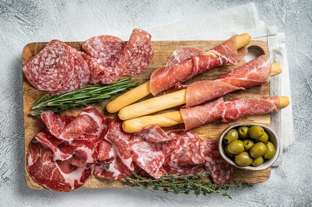 Antipasto platter cold meat plate with grissini bread sticks, Prosciutto crudo, Salami Coppa Sausage