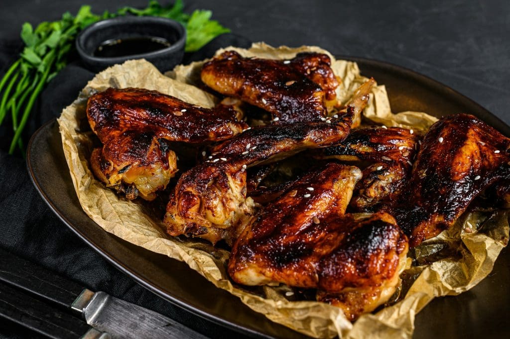 BBQ chicken wings. Farm organic poultry. Top view. Black background