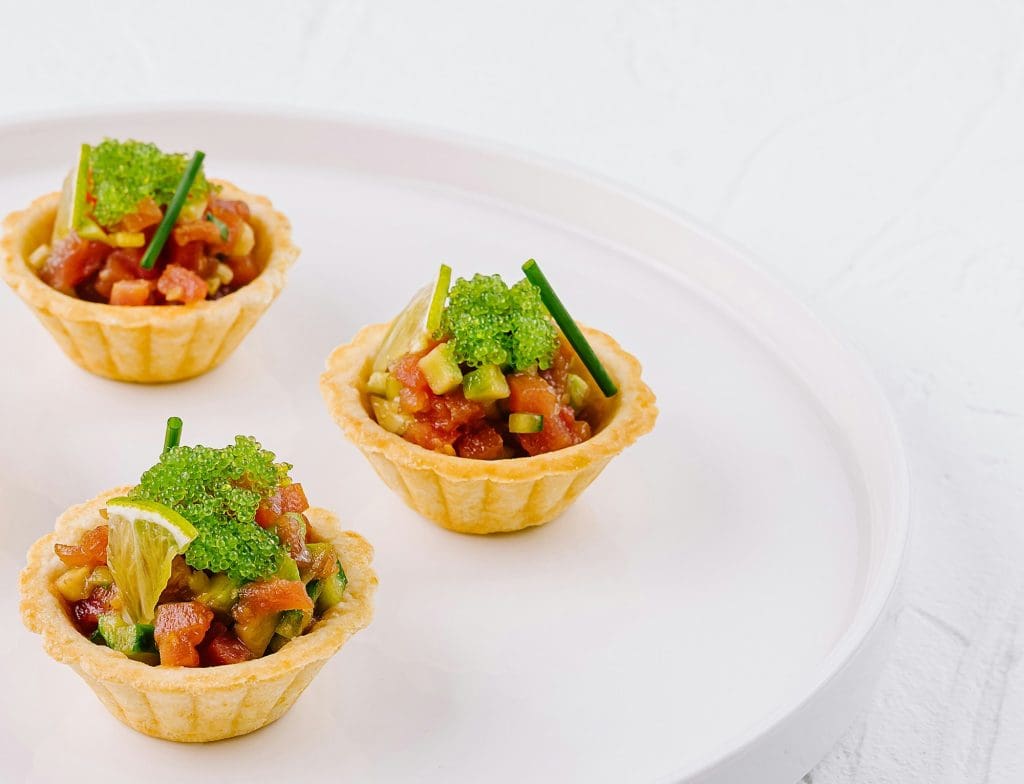 Fresh veggie tartlets on white plate