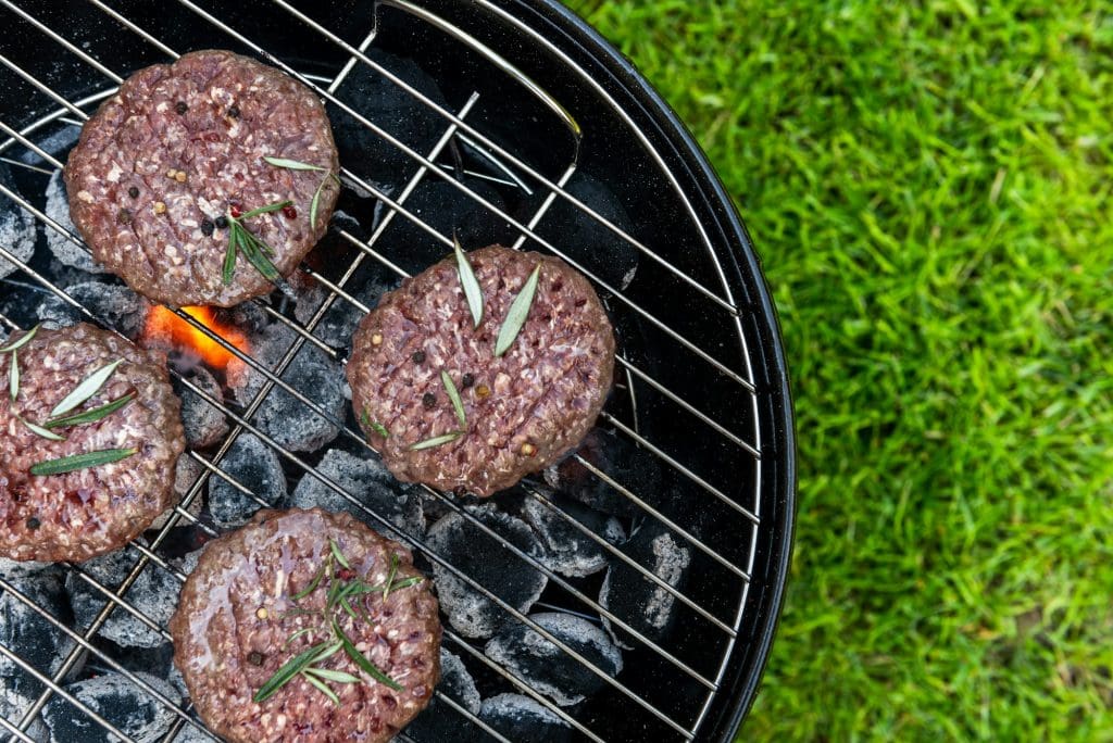 Meat Burgers Grilled on Charcoal Grill BBQ Close Up View