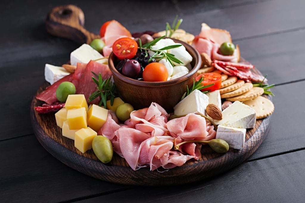 Antipasto platter with ham, prosciutto, salami, cheese, crackers and olives