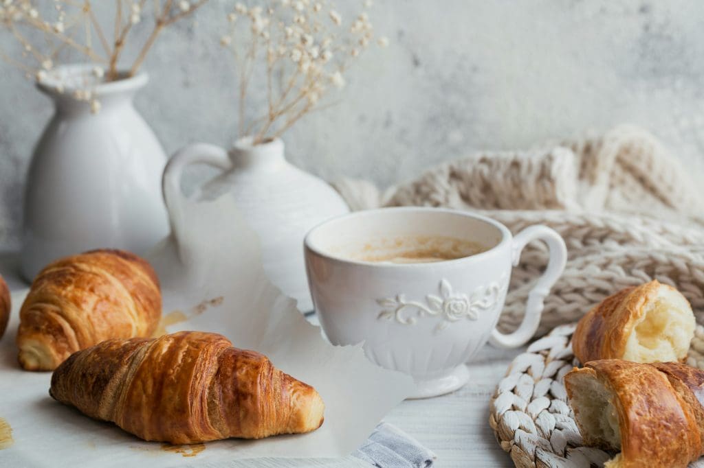Delicious breakfast with fresh croissants and cup of coffee